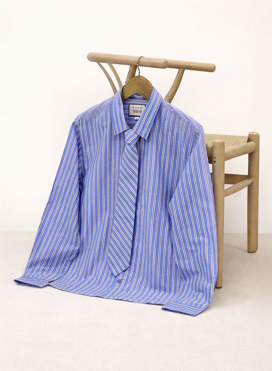 Blue and white striped shirt on a hanger against a white background