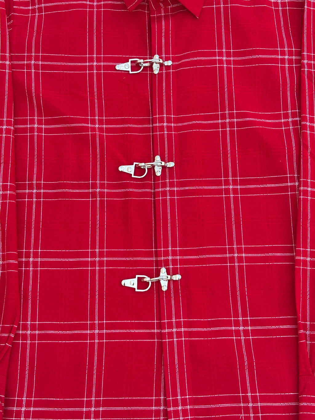 Close-up of a red plaid shirt with metal buttons