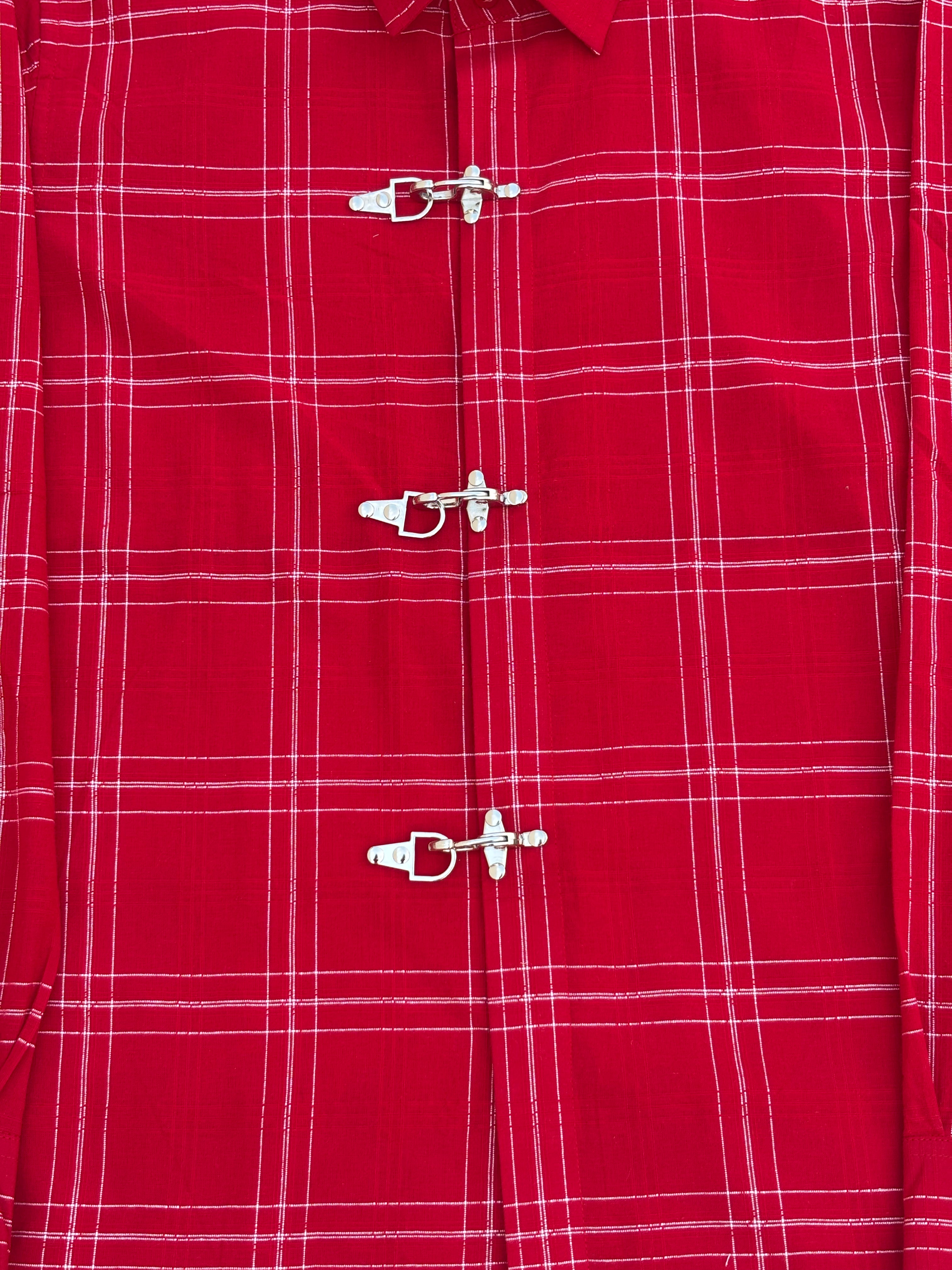Close-up of a red plaid shirt with metal buttons