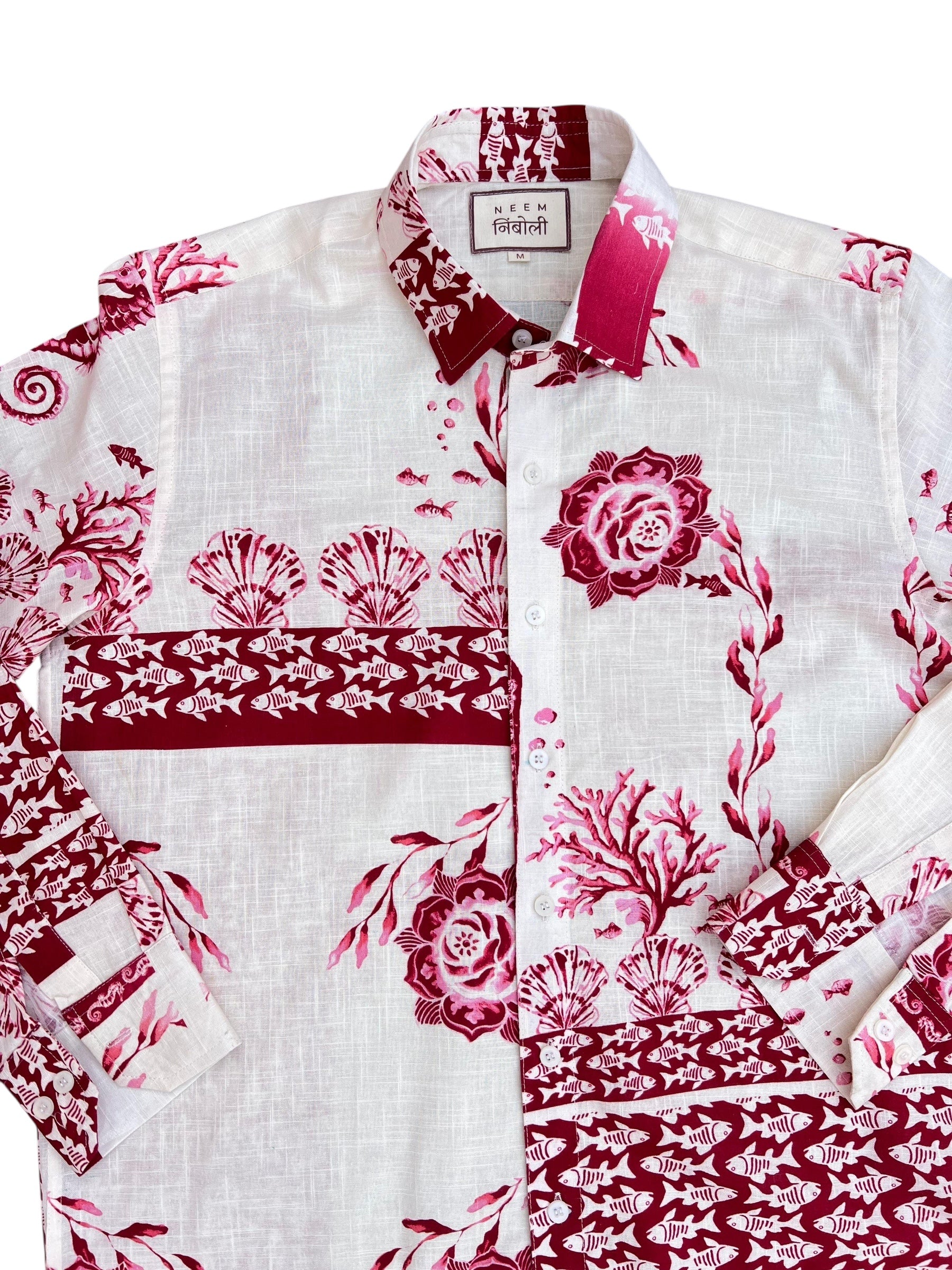 White shirt with red floral and fish patterns on a white background