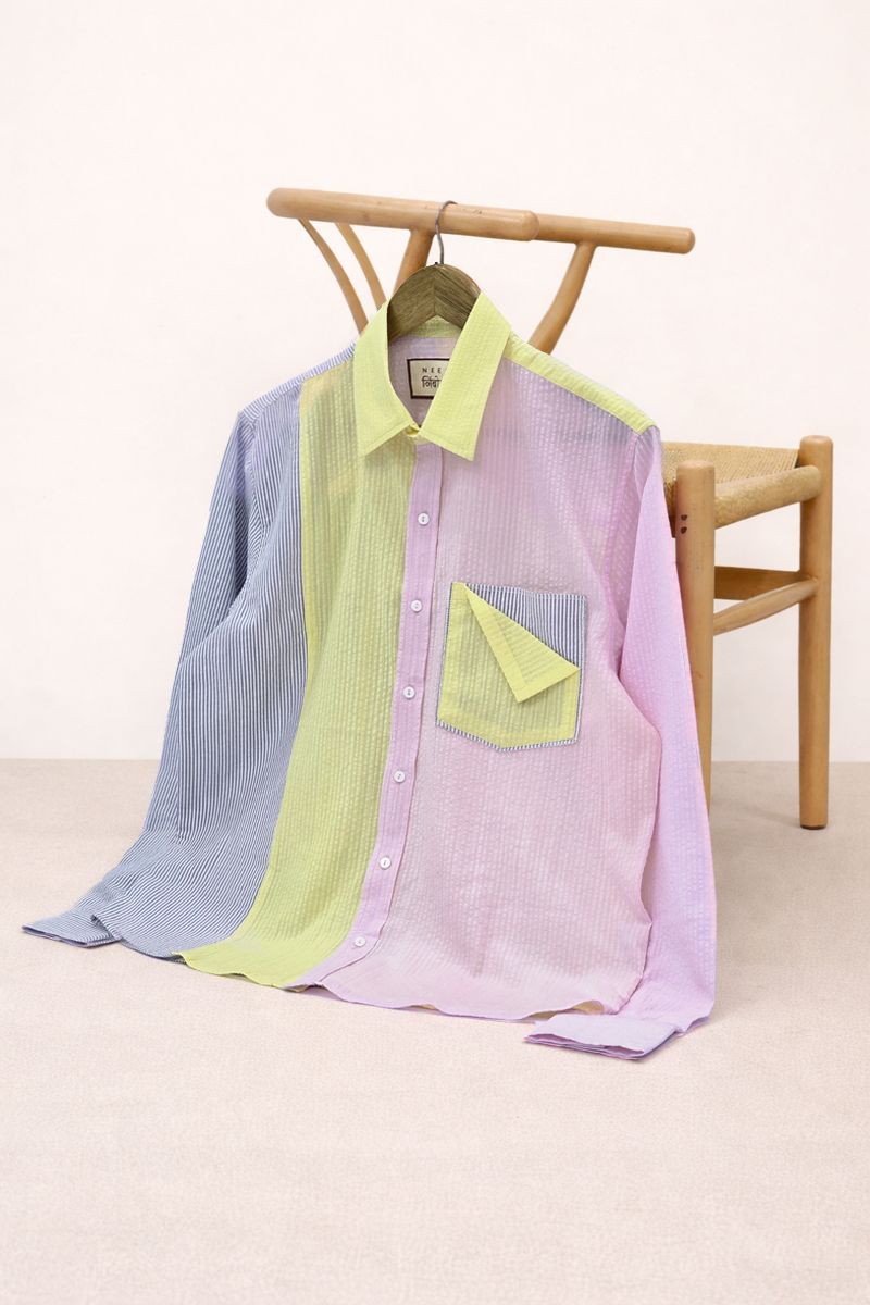 Color-blocked shirt on a wooden chair with a white background