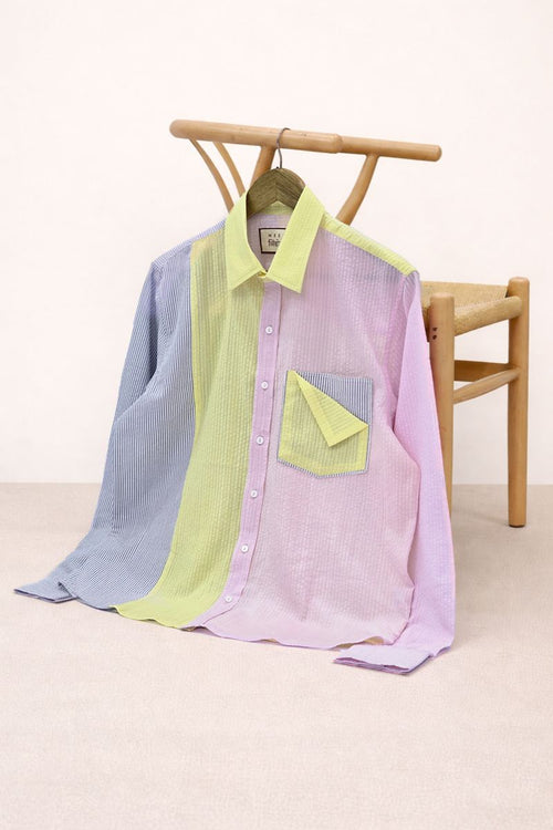 Color-blocked shirt on a wooden chair with a white background