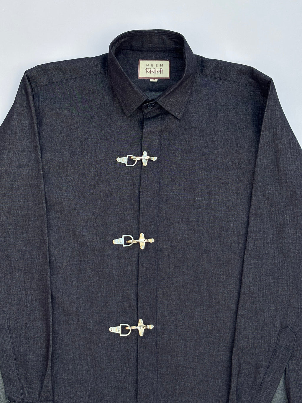 Dark blue jacket with silver buttons on a light gray background