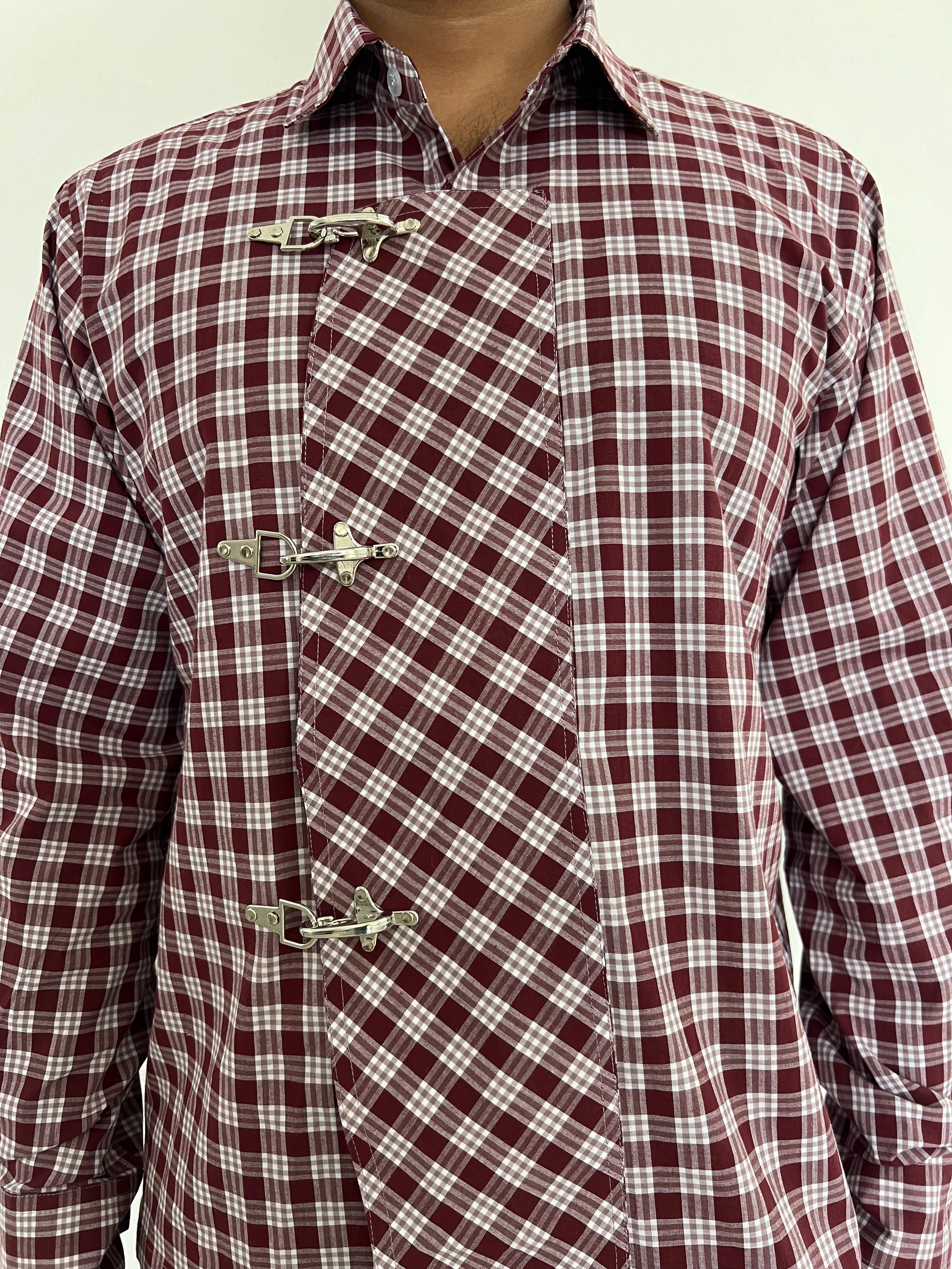 Maroon and white checkered shirt with decorative buttons on a plain background