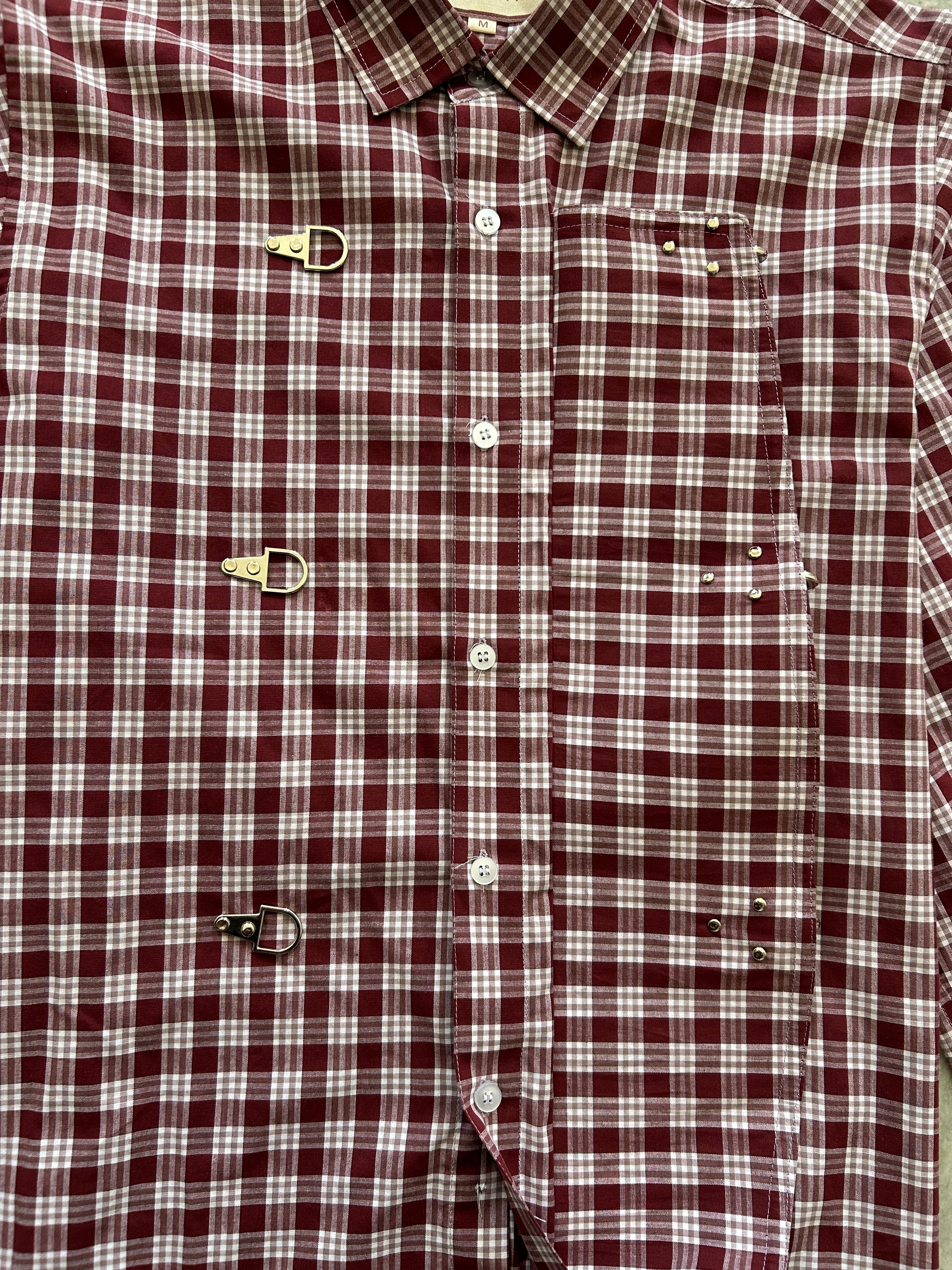 Close-up of a maroon and white checkered shirt with buttons and suspenders.