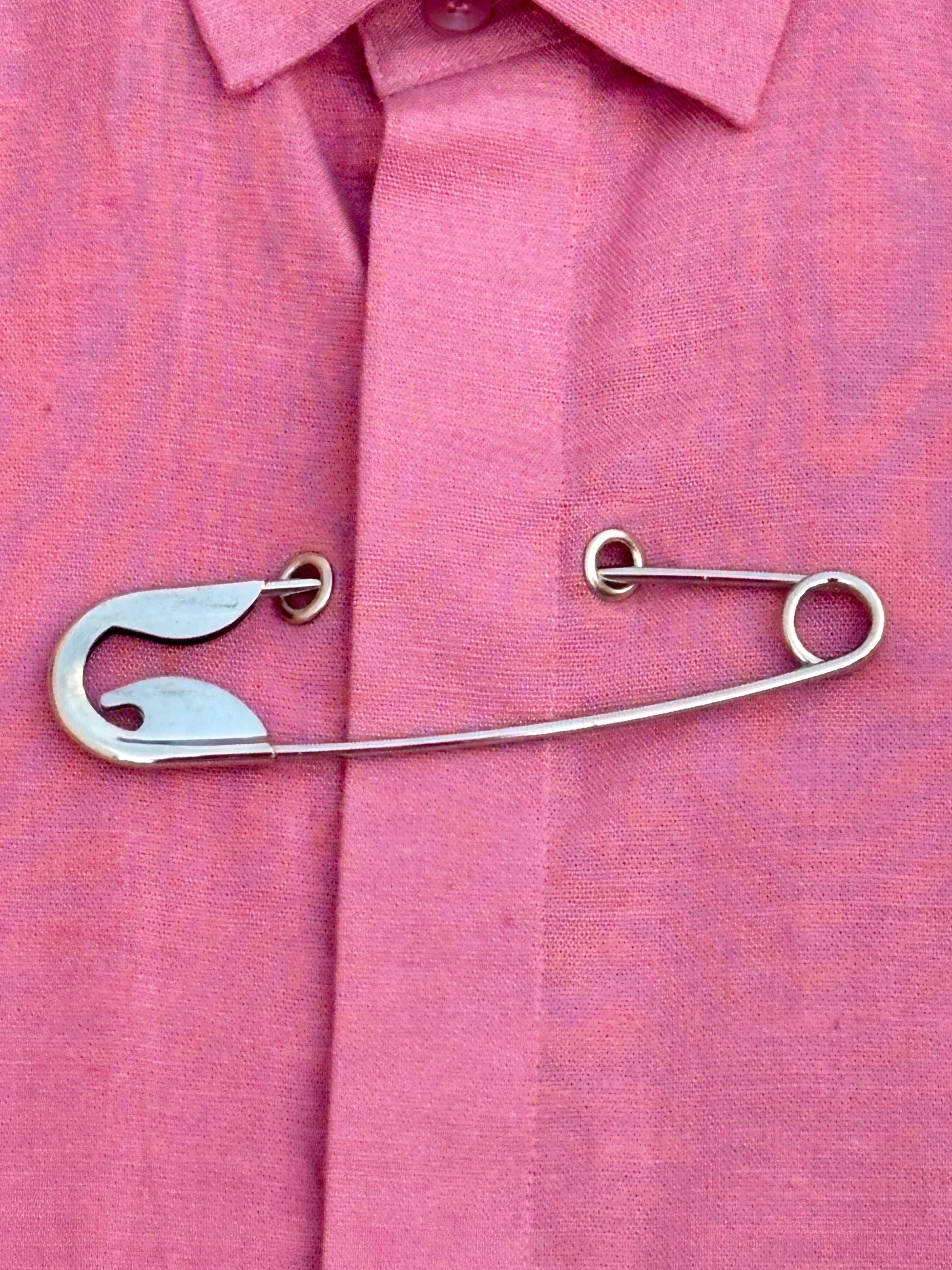 Metallic safety pin on a pink shirt