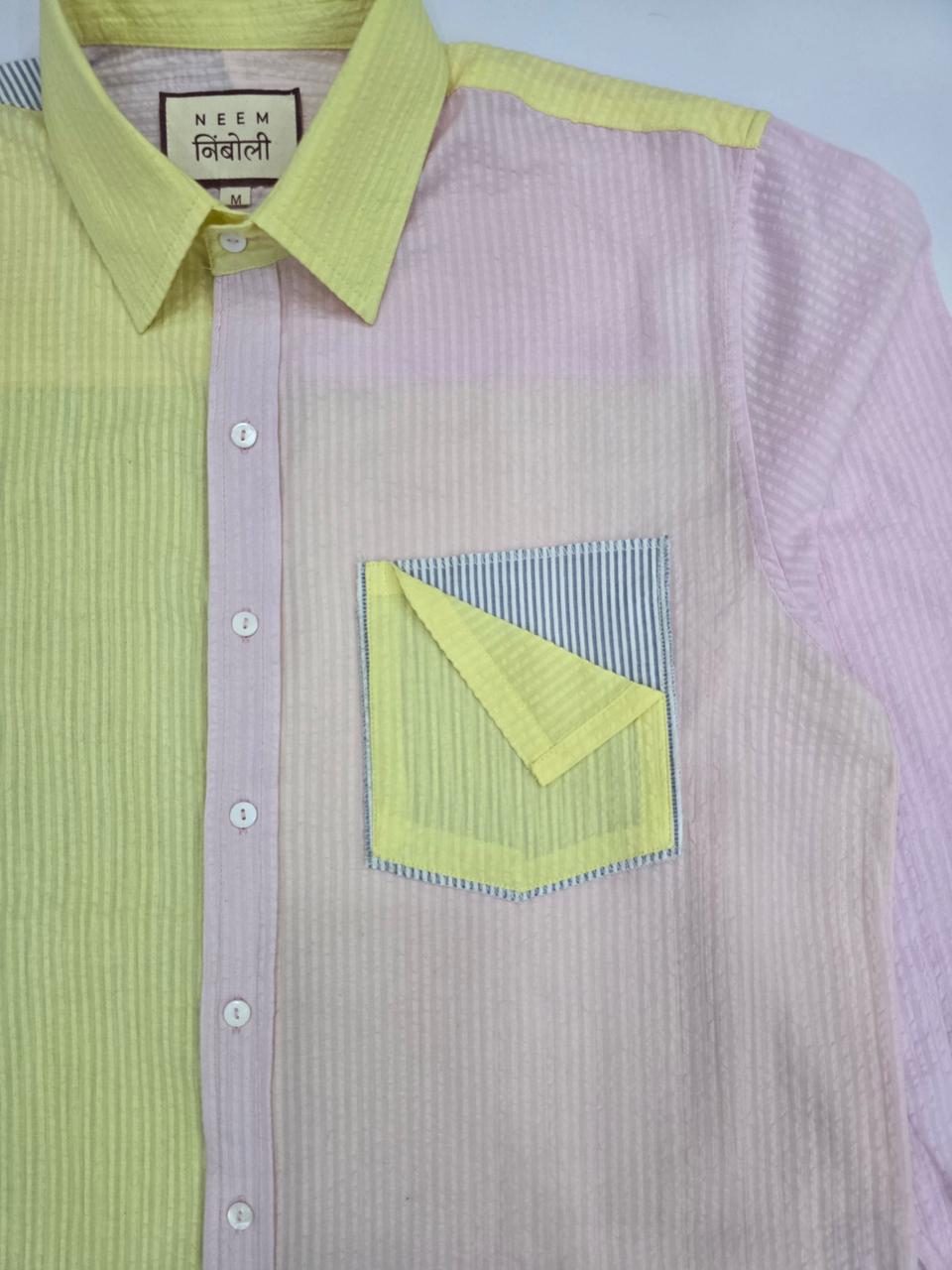 Pink and green checkered shirt with a pocket detail on a light blue background