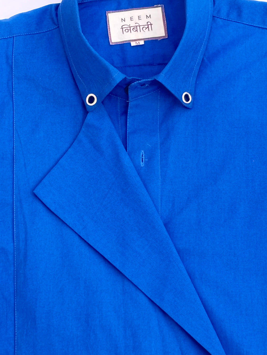 Blue shirt with a visible brand label on a white background