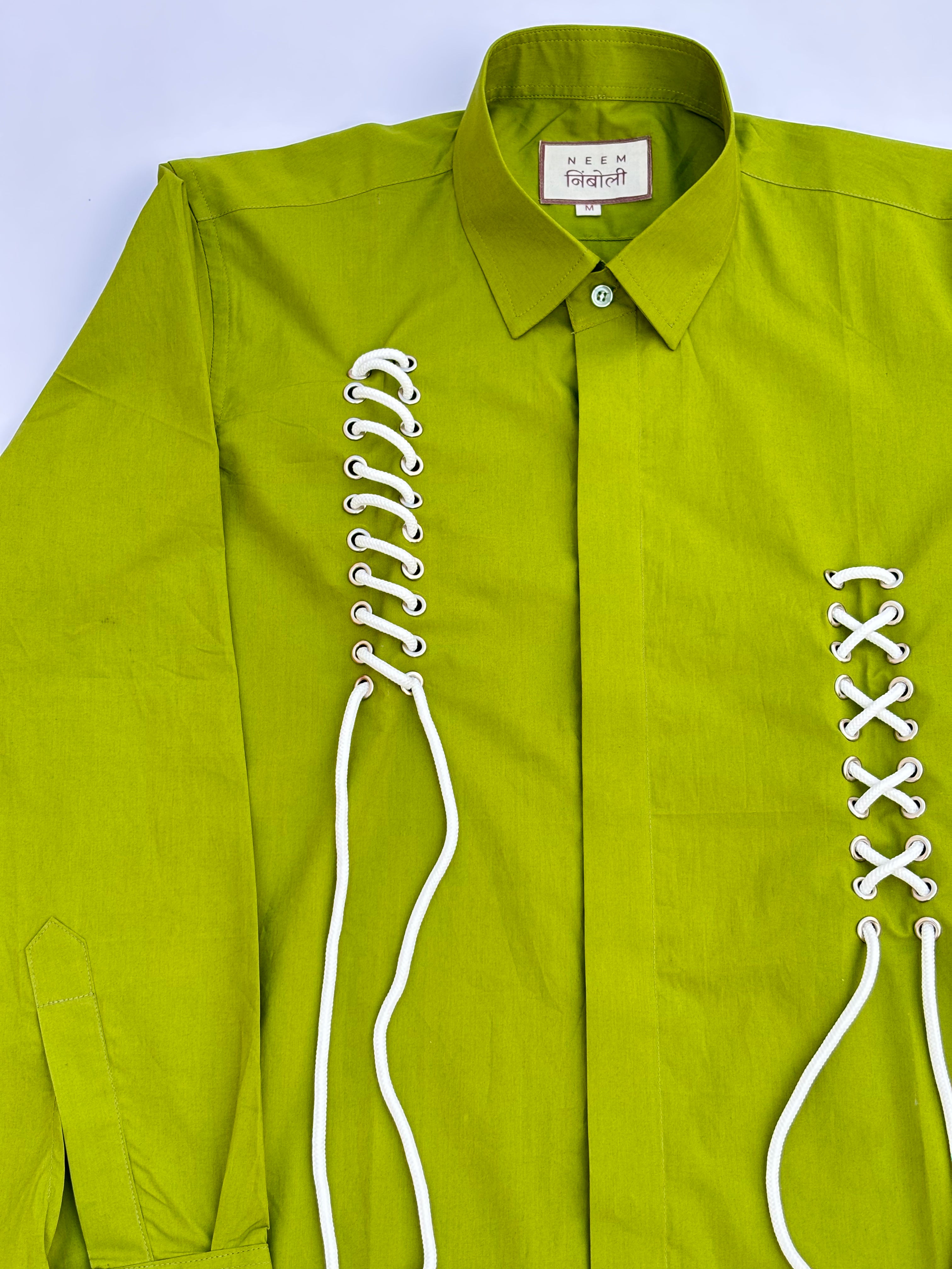 Green shirt with white lace details on a light blue background